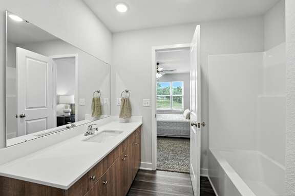 A bathroom with a white sink and mirror.