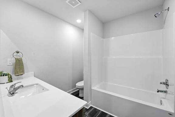 A white bathroom with a sink, toilet, and bathtub.