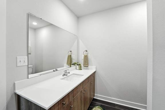A white sink in a bathroom with a mirror above it.