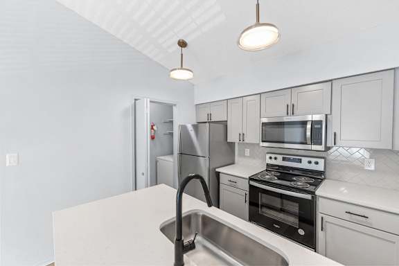 A kitchen with white cabinets and a stainless steel sink.