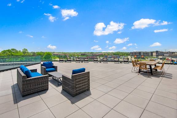 A patio with blue cushions and wicker furniture.