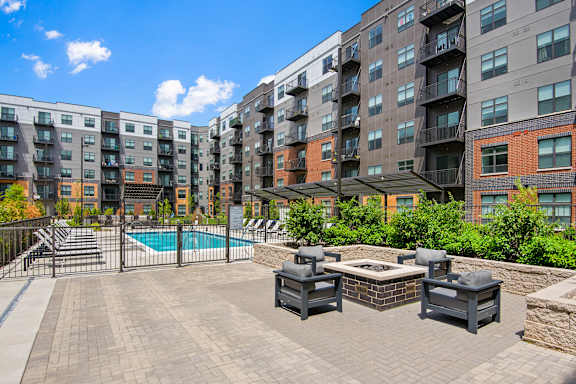 A large outdoor patio with a pool and lounge chairs.
