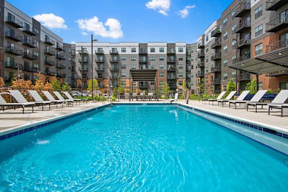 A swimming pool in front of apartment buildings.