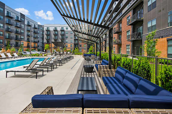 A pool area with sun loungers and a shaded seating area.