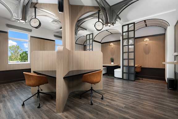 A modern office space with a curved desk and chairs.