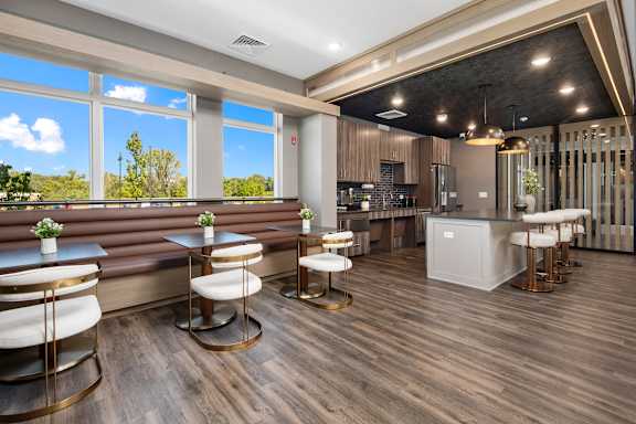 A modern bar area with wooden floors and a large window.