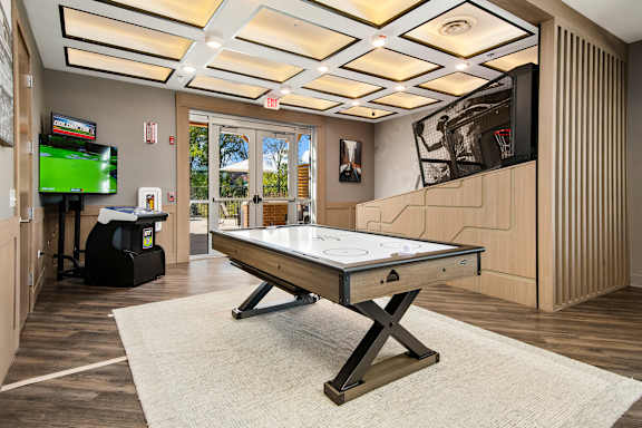 A room with a pool table and a television.