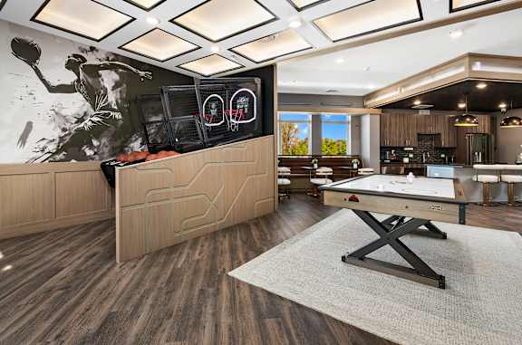 A room with a pool table and a large screen on the wall.
