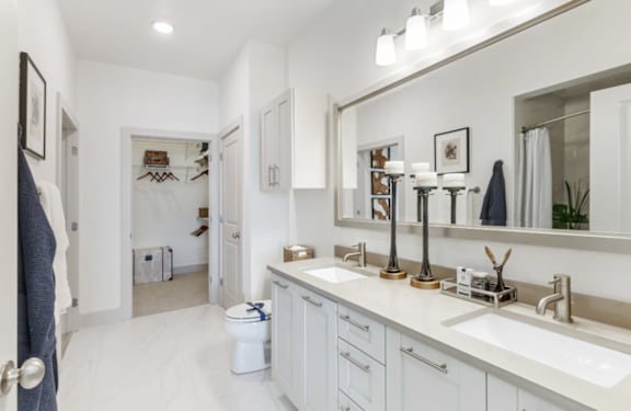 A bathroom with a toilet, sink, and mirror.