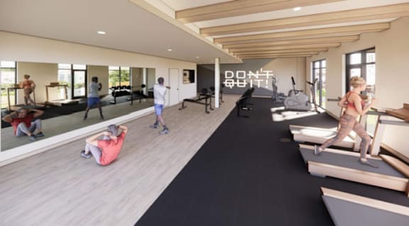 A gym with a black mat and people working out.