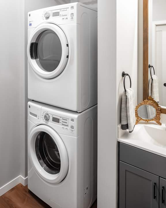 Two white front loading washing machines in a laundry room.
