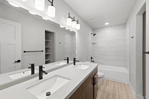 A bathroom with a white countertop and a white tub.