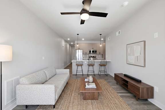 A living room with a white couch, a wooden coffee table, and a bar area in the background.