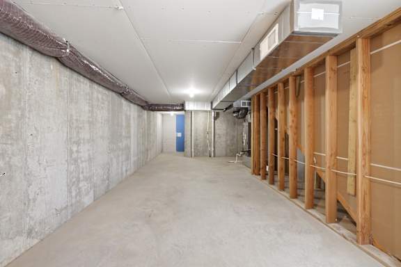 A long, empty hallway with a blue door at the end.