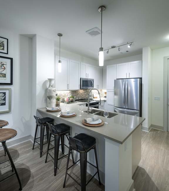 A kitchen with a bar area and a refrigerator.
