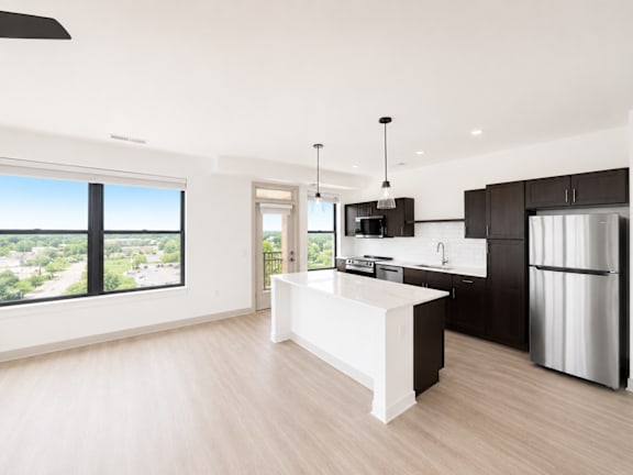 A modern kitchen with a large island and a view of the city.