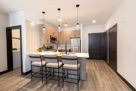 a kitchen with a large center island with a breakfast bar