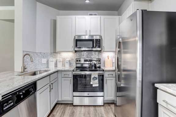 A modern kitchen with stainless steel appliances and white cabinets.