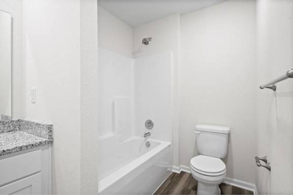 A white bathroom with a toilet, sink, and bathtub.