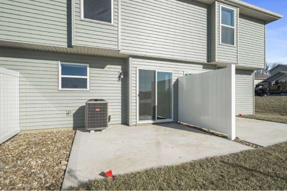 A house with a grey siding and a white fence.