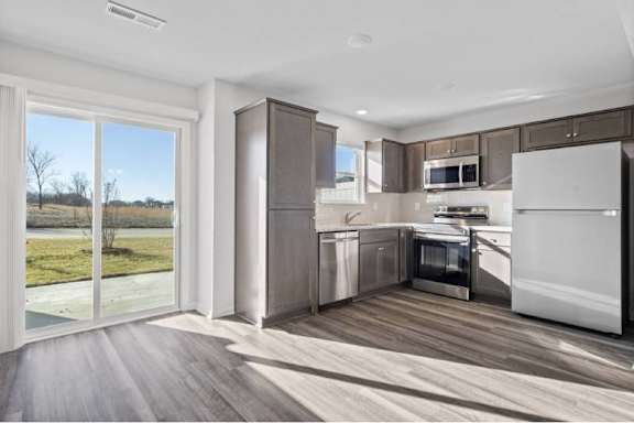 A modern kitchen with a refrigerator, oven, and microwave.