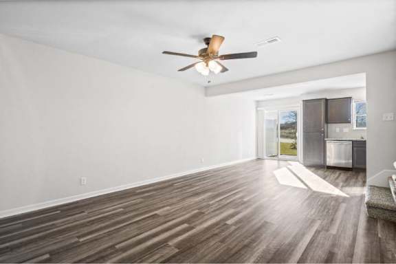 A room with a ceiling fan and wooden flooring.