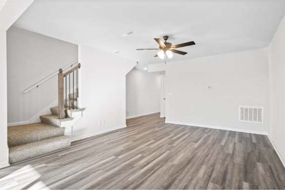 A room with a staircase and a ceiling fan.