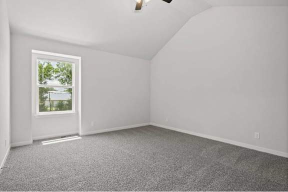 A room with a window and carpeted floor.
