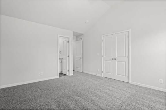 A room with white walls and a grey carpet.