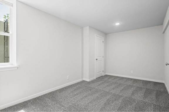 A room with a carpeted floor and a door.