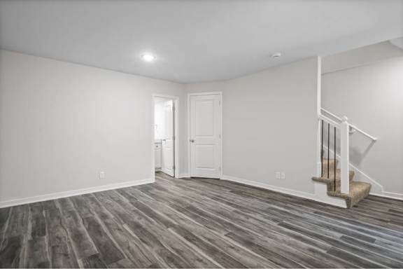 A room with a staircase and wooden flooring.