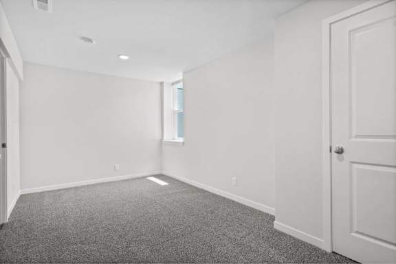 A room with a carpeted floor and white walls.