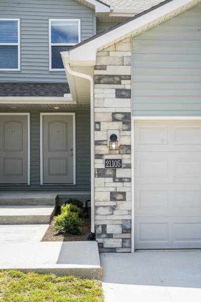 A house with a grey front door and a white garage door.