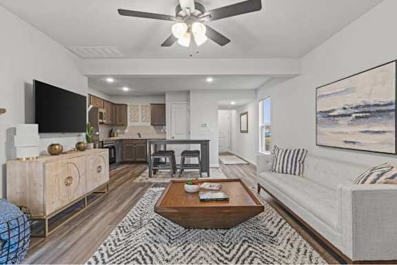A living room with a white couch and a wooden coffee table.