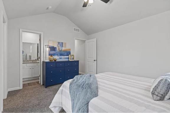 A bedroom with a bed, dresser, and mirror.