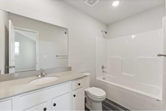 A white bathroom with a sink, toilet, and bathtub.