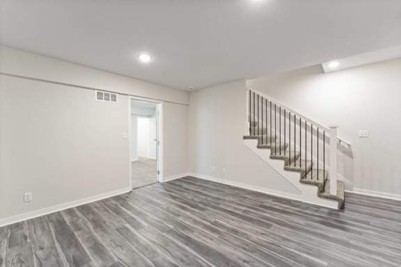 A room with a staircase and wooden flooring.