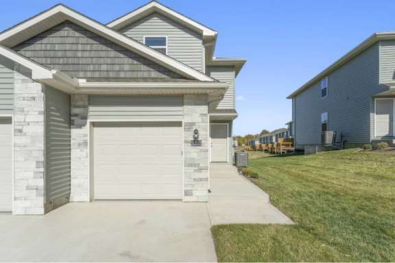 A house with a grey garage door is shown.