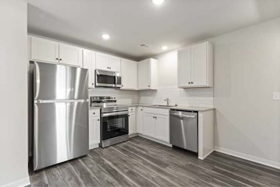 A modern kitchen with stainless steel appliances and white cabinets.