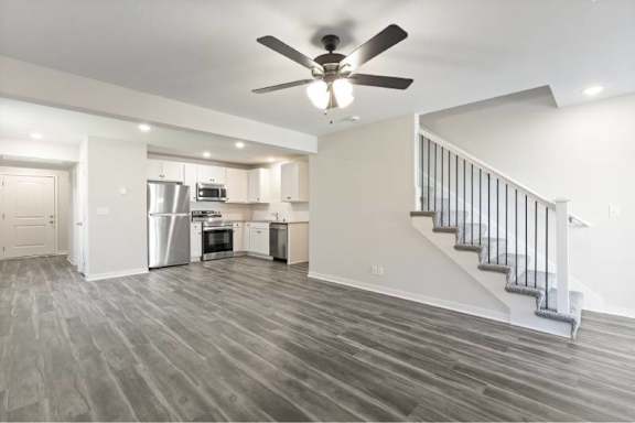 A spacious kitchen with a staircase leading to the upper floor.