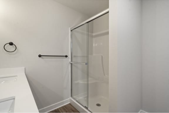 A white bathroom with a glass shower door.