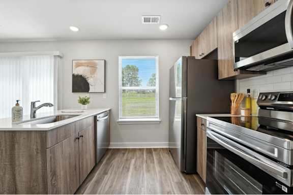 A modern kitchen with wooden cabinets and stainless steel appliances.