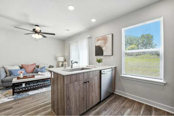 A modern kitchen with a wooden island and a ceiling fan.