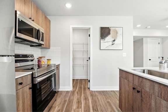 A kitchen with wooden cabinets and a white door.