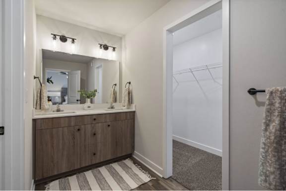 A bathroom with a mirror, lights, and a cabinet.