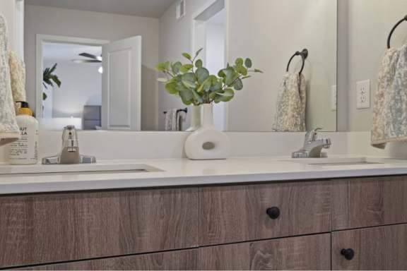 A bathroom with a white sink and a wooden cabinet.