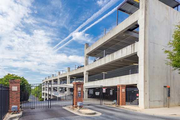 A parking garage with a black gate in front.
