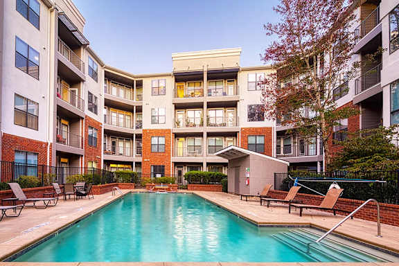 A swimming pool in front of apartment buildings.