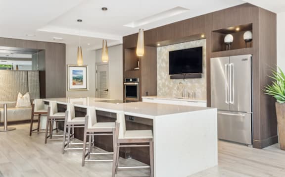 A modern kitchen with a white island and stainless steel appliances.