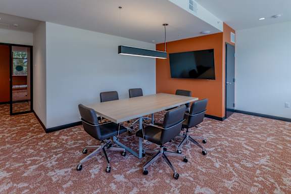 A conference room with a large table and chairs.